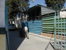 Man pushing garbage cart labeled "UN"