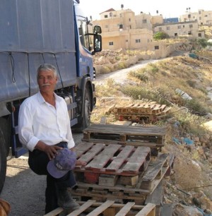 man standing beside truck and houses
